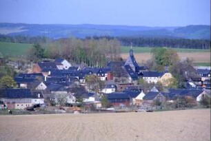 Blick über das Dorf; dunkle Dächer, Kirche ragt heraus
