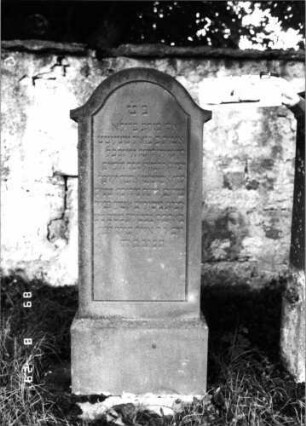 Grabstein 476 (Index: 100108039) Material: roter Sandstein Zustand: Stele am Sockel repariert Maße HxBxT: 160x61x26 cm Beschreibung: Stele, überkragender Konvexbogenabschluß, Schriftfeld abgegrenzt, getreppter Sockel: Grabstein 476