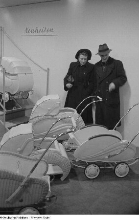 Besucher vor Kinderwagenmodellen