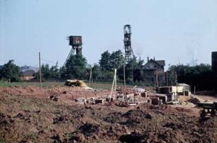 Oelsnitz, Albert-Funk-Schächte : Oelsnitz, Albert-Funk-Schächte (bis 1949 Vereinsglück-Schächte) II (links) und I des VEB Steinkohlenwerk Deutschland in Oelsnitz (Erzgeb.), Wohnhaus vorn rechts früheres Direktionsgebäude, später Wohnung Obersteiger, Hintergrund links Halde der Betriebsabteilung Deutschland des gleichen Werkes, Vordergrund Bau LPG Albert-Funk, Standort Albert-Funk-Schächte nach Stillegung zunächst VEB Baumechanisierung Lengenfeld, Betriebsteil Oelsnitz, heute BEFA Fahrzeug- und Stahlbau GmbH
