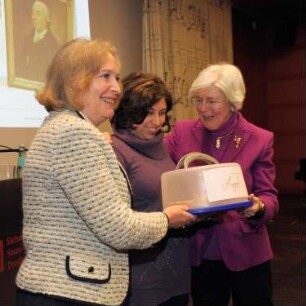 SLUB, Ausstellung "100 Jahre Bibliotheca Hertziana in Rom" : Ausstellungseröffnung im Vortragssaal. Überreichung eines Kuchens durch Kuratorin Carina Bauriegel, zwischen Prof. Dr. Sybille Ebert-Schifferer, Direktorin der Bibliotheca Hertziana, und Prof. Dr. Elisabeth Kieven, geschäftsführende Direktorin der Bibliotheca Hertziana,