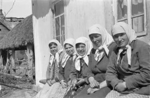 Zweiter Weltkrieg. Zur Einquartierung. Sowjetunion. Frauen und Mädchen auf einer Bank vor einer Bauernhütte