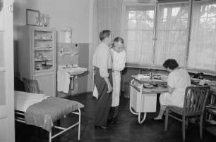 Patient, Arzt und eine Frau während einer medizinischen Untersuchung