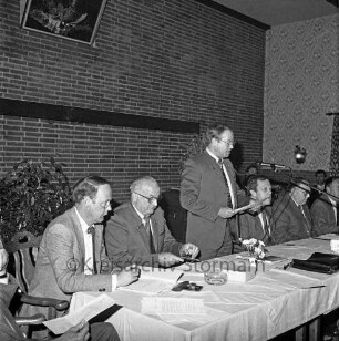Kreisjägerschaft Stormarn e.V.: Rohlfshagen/Kupfermühle: Gastwirtschaft "Kupfermühle": Saal: Mitgliederversammlung: Podium mit Gremienmitgliedern: Rede des Kreisjägerschaftsvorsitzenden Hans Bünning
