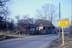 Straßengabelung mit Ortsschild, Gebäude