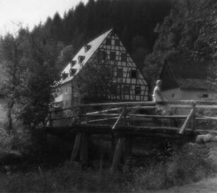 Autotour Fränkische Schweiz : Autotour Fränkische Schweiz. Junge Frau auf einer Brücke vor einem Fachwerkhaus