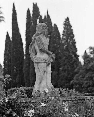 männliche Figur mit Umhang und einer Schale in der linken Hand