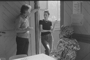Höfgen. Akt-Pleinair 1979. Die Fotografen Günter Rössler und Eva Mahn im Gespräch, am Tisch sitzt ein Fotomodell mit Turban