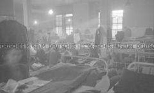 Selbstversenkung des Hochseepassagierdampfers "Columbus" am 19. Dezember 1939, Besatzungsangehörige im Internierungslager auf Ellis Island, im Schlafsaal auf einfachen Feldbetten sitzend