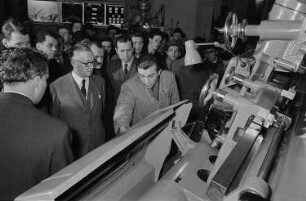 Messebesucher beim Betrachten einer technischen Anlage in der Ausstellungshalle der Sowjetunion