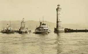Hafeneinfahrt, Lindau am Bodensee : Zwei Dampfschiffe in der Hafeneinfahrt mit Leuchtturm und "Lindauer Löwe" (von Johann von Halbig). Blick zum Bregenzer Wald
