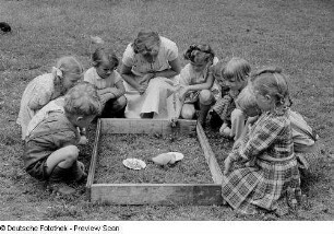 Kinder beim Beobachten eines Entenkükens