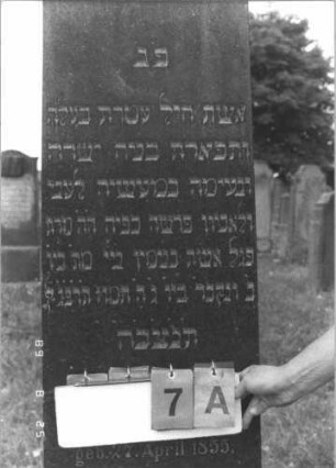 Grabstein 7 (Index: 100108053) Material: schwarzer Granit, Sockel Kunststein Maße HxBxT: 184x40x16 cm Beschreibung: Obelisk, getreppter Sockel: Grabstein 7A