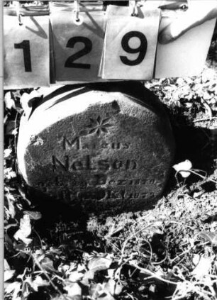 Grabstein 129 (Index: 99792234) Material: Sandstein Zustand: verwittert und beschädigt mit Textverlust Maße HxBxT: 34x29x11 cm Beschreibung: Stele, Segmentbogenabschluß Symbolik: Blüte Besonderheit: Kindergrab: Grabstein 129