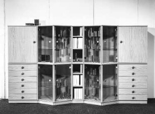 Anbauwand : Dresden-Hellerau. VEB Deutsche Werkstätten Hellerau. Hausmesse, 1986.Anbauwand. Holz, folienbeschichtet in Kirschbaumholzoptik (1986; VEB Deutsche Werkstätten Hellerau)