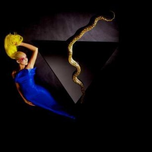 Model mit blauem Kleid, gelber Perücke und Schlange