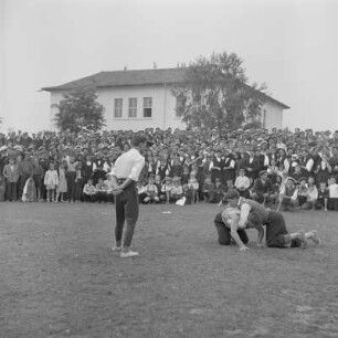Dorffest. Dorfbewohner als Zuschauer verfolgen der Darbietung des Ringkampfes der Schüler