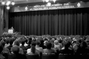 40. Tagung 1990 Mediziner: Ganzer Saal mit Ansprache Rita Süssmuth und Aufschrift "Herzlich Willkommen zur 40. Tagung der Nobelpreisträger"