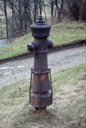 freistehender alter Hydrant am Wegesrand