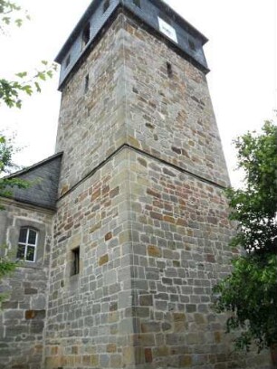 Evangelische Kirche - Kirchturm von Nordwesten (Untergeschoß romanisch erbaut-Obergeschoß gotisch erneuert-verschieferte Glockenstube 18 Jhd) mit Schießscharten (Schlitzscharten) im Obergeschoß