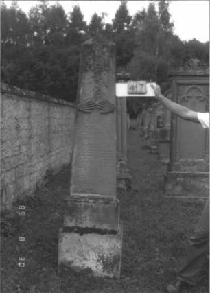 Grabstein 47 (Index: 99609683) Material: Sandstein Zustand: stark verwittert Maße HxBxT: 227x49x32 cm Beschreibung: Obelisk, getreppter Sockel Symbolik: segnende Hände: Grabstein 47