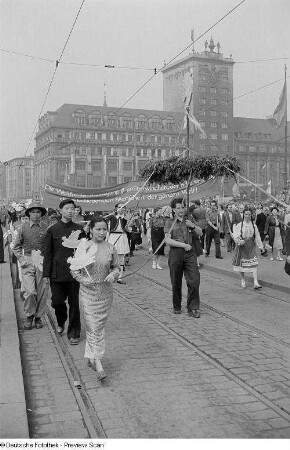 Asiatische Teilnehmer im Demonstrationszug beim Vorbeimarsch an der Ehrentribüne auf dem Karl-Marx-Platz (heute: Augustusplatz), im Hintergrund das Kroch-Hochhaus