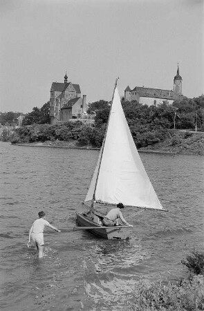 Zwei junge Männer mit einer Jolle auf dem Süßen See bei Seeburg, im Hintergrund das Schloss Seeburg