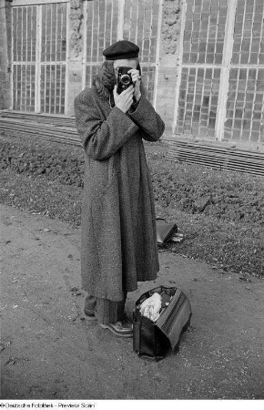 Renate Rössing mit Kamera vor der Gärtnerei der Orangerie des Schlosses Belvedere