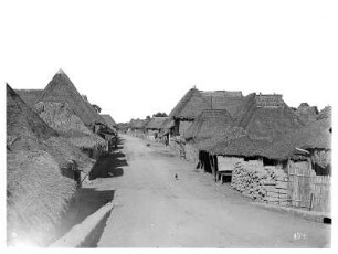 Manila, Philippinen. Straße in eine Wohnhaussiedlung mit traditionellen Nipa-Hütten aus Bambus