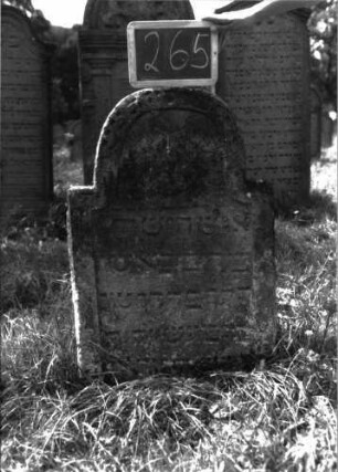 Grabstein 265 (Index: 100103203) Material: Sandstein Zustand: teilweise verwittert, eingesunken, dadurch Textverlust Maße HxBxT: 95x58x10 cm Beschreibung: Stele, stark erhöter, eingezogener Rundbogenabschluss, Schriftfeld eingetieft, im Bogenfeld Levitenkanne Symbolik: Levitenkanne: Grabstein 265