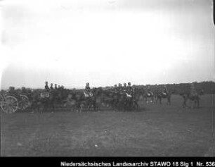 Geländeübung und Besichtigung des Feld-Artillerie-Regiments Nr. 46 Enthält: Soldaten auf mit Pferden bespannten Geschützlafetten auf dem Marsch, davor: berittene Offiziere