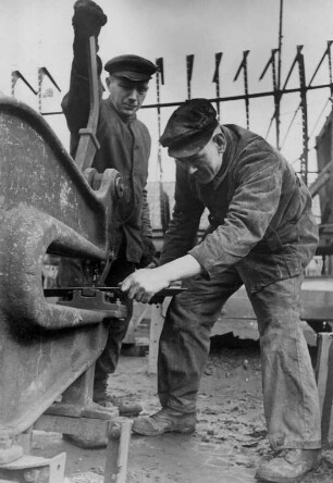 Auf einer Werft. Arbeiter schneiden mit einer Stahlschere Blechstreifen