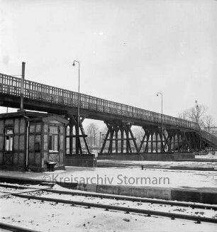 Bahnhofsgelände: Holzbrücke für Fußgänger, über westliche Gleisanlagen: vorne Fachwerkschuppen: Lichtmasten: im Hintergrund Mommsenstraße: im Winter