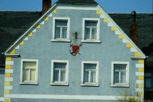 Hausgiebel mit Dekoration: Herz, Anker und Schwert