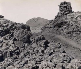 Weg durch eine Lavawüste, oben rechts ein 'Steinmann' (Wegweiser), Island