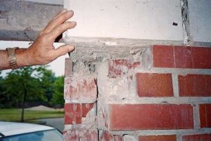Eckhorst: Gymnasium Eckhorst: Bauschaden an Betonsturz und Mauerwerk bei Eingang: Männerhand, hinten Stützbalken: 28. Juni 2001