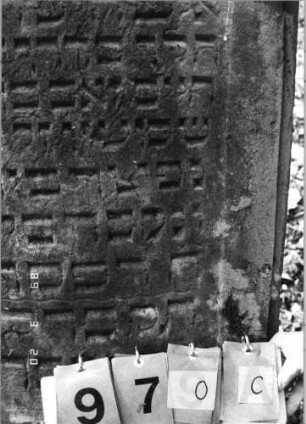 Grabstein 970 (Index: 99751399) Material: Sandstein Zustand: leicht verwittert Maße HxBxT: 105x62x13 cm Beschreibung: ädikulaart. Stele mit Pilastern, eingezog. Segmentbogenabschl. , Schrift eingetieft: Grabstein 970C