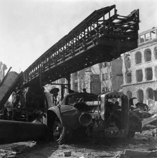Verbrannter Feuerwehrzug (Feldgasse) / Ausgebrannte Feuerwehren : Dresden. Feuerwehrfahrzeug mit Drehleiter in Fahrstellung, auf dem Weg zum Einsatz zerstört und ausgebrannt