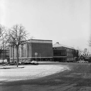 Erweiterungsbau [später Gebäude C] mit Kreistagssitzungssaal: vor Fertigstellung: vorn Busbahnhof und Mommsenstraße: hinten rechts Reimer-Hansen-Straße: links Bäume: dahinter Hauptgebäude [später Gebäude A]: Winter