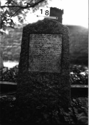 Grabstein 18 (Index: 100081767) Material: Granit, weiße Marmorplatte Zustand: gut Maße HxBxT: 117x53x40 cm Beschreibung: Stele, Segmentbogenabschluß, rechteckige Schriftplatte: Grabstein 18
