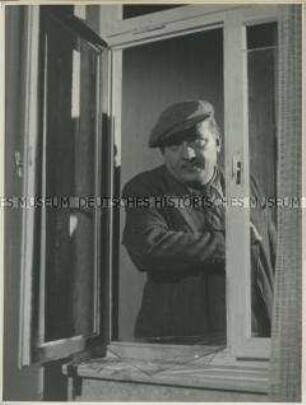 Gestelltes Foto mit Einbrecher vor zerbrochenem Fenster