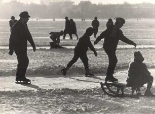 Hamburg. Die Außenalster im Winter 1963. Auf dem zugefrorenen Gewässer wird Schlittschuh gelaufen. Mancher spaziert auch nur über die Eisfläche