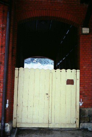 Bahnhof: überbauter Durchgang und mit Holztor