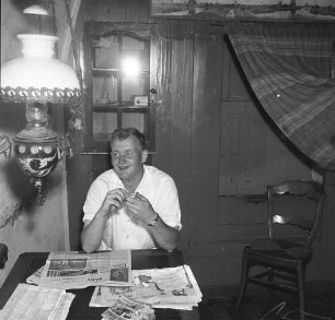 Wohnraum einer Windmühle. Ansicht mit am Tisch sitzenden Mann (Müller?)