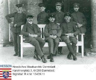 Gemeinder, Peter (1891-1931) / Porträt in Uniform als Offiziersstellvertreter in Bad Nauheim / Gruppenaufnahme, stehend 1. v. l., Ganzfigur auf Postkarte an Frau Marie