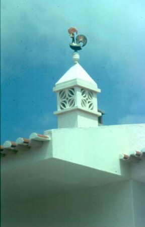 Schornstein mit Wetterhahn auf der Spitze