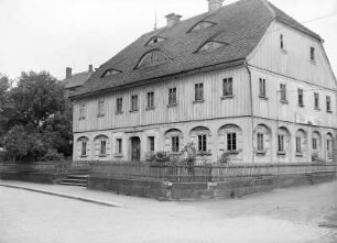 Umgebindehaus. Seifhennersdorf, Rumburger Str. 8 : Seifhennersdorf, Rumburger Straße 8. Wohnhaus (ehemalige Faktorei, Katasternummer 599 ) eines ehemaligen Vierseithofes (Umgebindehaus, bezeichnet 1829). Eckansicht mit Einfriedung auf Stützmauer, Straßenseite