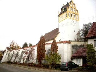 Ansicht von Südosten mit Kirche (im Kern Romanisch-Gotisch überarbeitet und später überformt) über Kirchhofmauer (Wehrgang im 18 Jh abgetragen) in Lage zu ebener Erde am Ortsrand