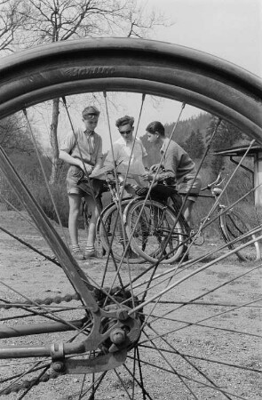 Drei junge Radfahrer studieren die Landkarte, im Vordergrund ein Rad des Reifenherstellers Barum