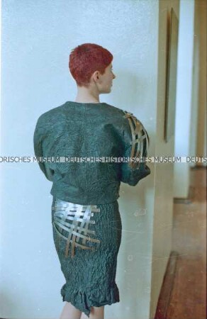 Modell in grauem Lederkostüm mit Metallbändern (Rückseite) der Designergruppe Allerleirauh